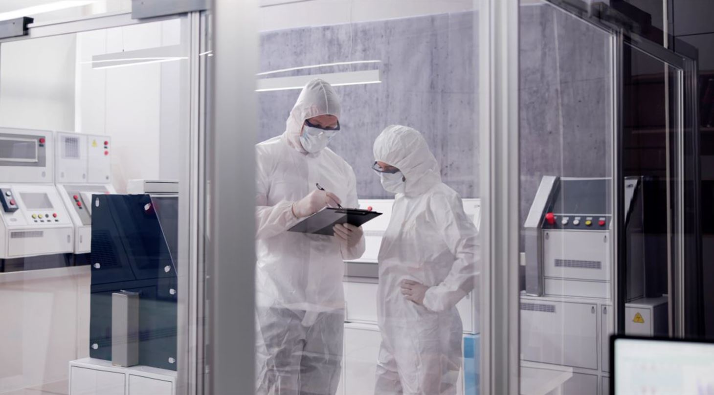 Et laboratorie eller renrum hvor der st�r to personer i kitler og udstyr